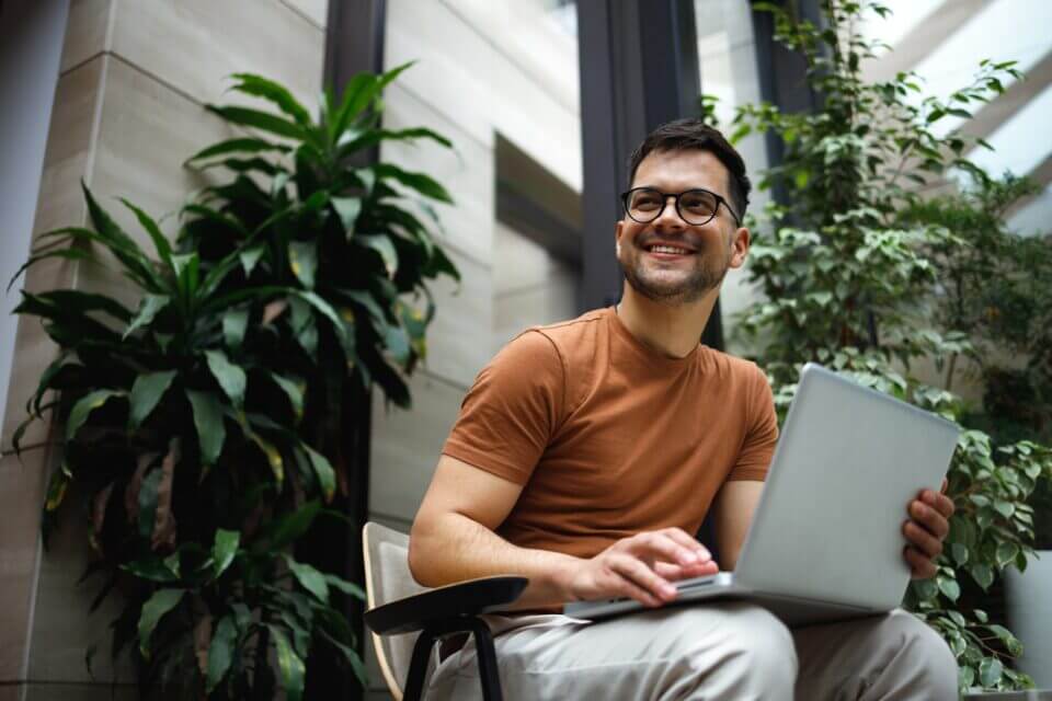 a man sitting on a chair with a laptop