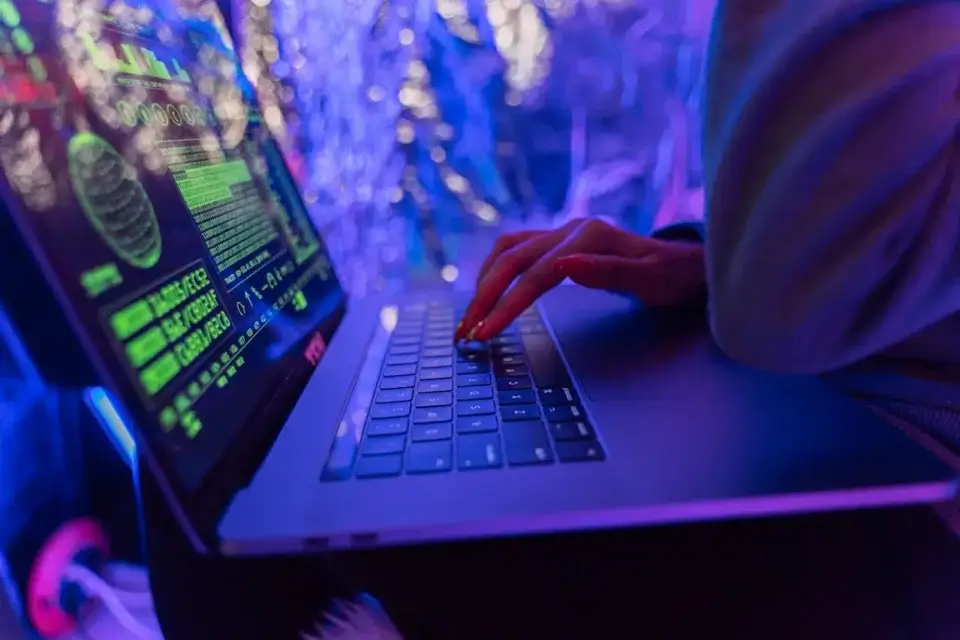 Person typing on laptop in neon